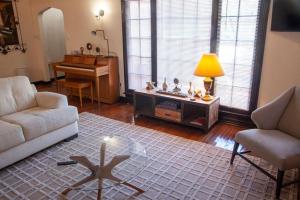 een woonkamer met een bank, een tafel en een piano bij Hidden Weekend Getaway in NoHo in Los Angeles