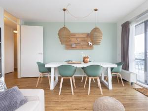 a dining room with a white table and chairs at Modern apartment close to the beach and the sea in Scheveningen