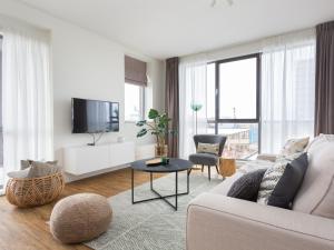a living room with a couch and a tv at Modern apartment close to the beach and the sea in Scheveningen