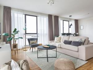 a living room with a white couch and a table at Modern apartment close to the beach and the sea in Scheveningen