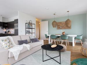 ein Wohnzimmer mit einem weißen Sofa und einem Tisch in der Unterkunft Modern apartment close to the beach and the sea in Scheveningen