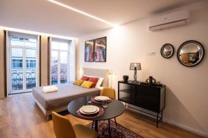 uma sala de estar com uma cama e uma mesa em Lemago Porto Apartments - Poveiros no Porto