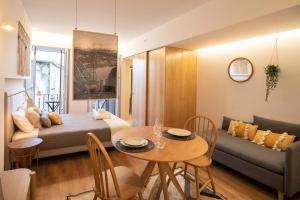 Cette chambre comprend un lit, une table et un canapé. dans l'établissement Lemago Porto Apartments - Poveiros, à Porto