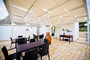 Villa CastelliにあるB&B Masseria Nuove Caselleの天井のパティオ(黒いテーブルと椅子付)