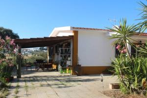 Dieses weiße Haus verfügt über eine Terrasse mit einem Tisch. in der Unterkunft Gosto do Campo in Lavre