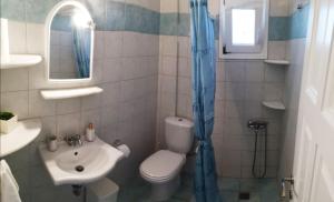a bathroom with a toilet and a sink at Paros Iliahtides Apartments near Golden Beach in Márpissa