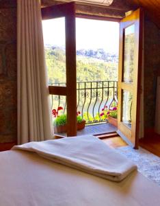 a bedroom with a bed and a window with a view at Pedacinho de Mundo Douro in Passinhos de Cima