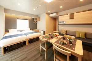 een slaapkamer met een bed en een tafel en een eetkamer bij MONday Apart Premium UENO OKACHIMACHI in Tokyo