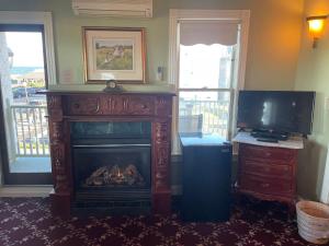 a living room with a fireplace and a television at Laingdon Hotel in Ocean Grove