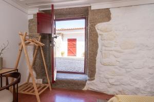 Cette chambre dispose d'une porte s'ouvrant sur un mur en pierre. dans l'établissement Quinta do Rio Noémi, à Guarda