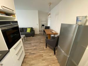 KG38 - Modern Living Vienna في فيينا: مطبخ مع ثلاجة ستانلس ستيل وغرفة معيشة
