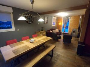 sala de estar con mesa de madera y sillas rojas en Le Flocon Vosgien, en Le Tholy
