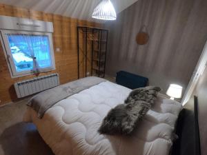 Un dormitorio con una cama con almohadas peludas. en Le Flocon Vosgien, en Le Tholy