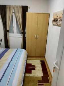 a bedroom with a bed and a cabinet and a window at Guest House RG in Žabljak