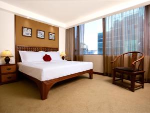 a bedroom with a bed and a chair and a window at Butterfly on Wellington, Central in Hong Kong