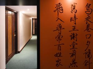 a wall with chinese writing on it next to a hallway at Butterfly on Wellington, Central in Hong Kong