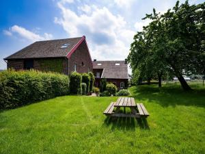 una mesa de picnic en el césped frente a una casa en Lush Mansion in Voeren with Private Garden, en Voeren