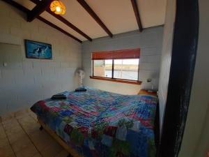 a bedroom with a bed in a room with a window at Pelican Point Waterfront Resort formerly Carnarvon Beach Retreat in Carnarvon