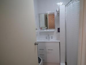 uma casa de banho branca com um lavatório e um espelho em Bega Southtown Motor Inn em Bega