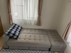ein Sofa in einem Zimmer mit Fenster in der Unterkunft Bessalov Home 2nd room friendly house in Tokio