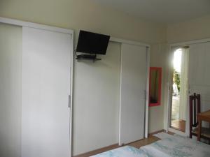 um quarto com uma televisão em cima de um armário branco em Aconchego Valparaíso em Petrópolis