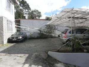 two cars parked in a parking lot next to a building at Aconchego Valparaíso in Petrópolis