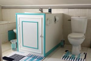a bathroom with a toilet and a sink at La porte bleue in Baie-Mahault