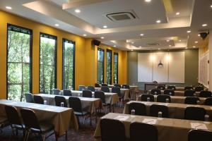 une chambre avec des tables et des chaises dans une chambre avec des fenêtres dans l'établissement Hua Hin Grand Hotel and Plaza - SHA Extra Plus, à Hua Hin