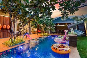 patio trasero con piscina con tobogán y parque infantil en Emmy pool villa-1(Cha-am), en Cha Am