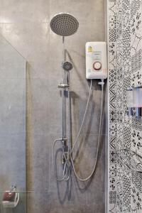 La salle de bains est pourvue d'une douche avec un pommeau de douche. dans l'établissement Emmy pool villa-1(Cha-am), à Cha Am