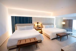 a hotel room with two beds and a table at Hard Rock Hotel & Casino Punta Cana - All Inclusive in Punta Cana