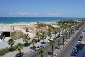 uma vista aérea de uma rua com palmeiras e uma praia em Sea view apartment em Bat Yam