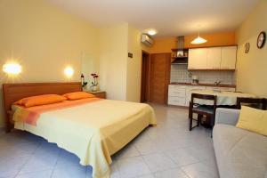 a bedroom with a large bed and a kitchen at Marija's House in Portorož