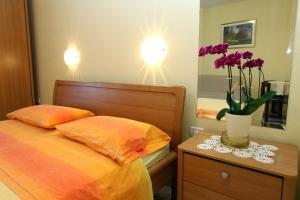 een slaapkamer met een bed en een vaas met bloemen op een tafel bij Marija's House in Portorož