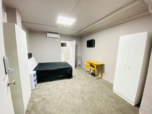 um quarto com uma cama e uma secretária em HIT Hostel em Auckland