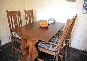 una mesa de madera con un tazón de naranjas. en Griffiths Cottage en Burra