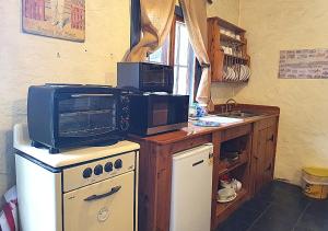 a kitchen with a microwave on top of a stove at Griffiths Cottage in Burra