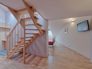 a living room with a wooden staircase and a tv at Beauty of Krakow Apartment in Krakow