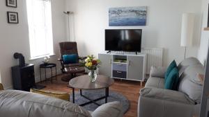 a living room with a couch and a tv at Rock Quay in Killyleagh
