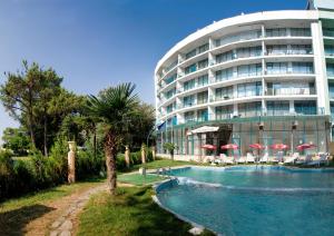 a hotel with a swimming pool in front of a building at Top-located Beach Apartment with Balcony in Sunny Beach