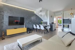 salon z kanapą i telewizorem na ścianie w obiekcie Casa Lori w mieście Rošini