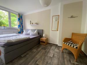 a bedroom with a bed and a chair and a window at Feriendomizil Achtern Öwer in Lohme