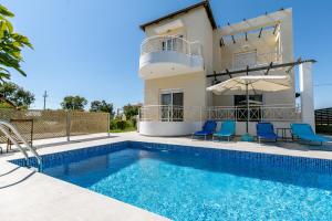 a villa with a swimming pool and a house at Rose Garden House in Kremasti