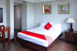 a bedroom with a bed with a red pillow on it at Super OYO 791 Bell Mansion in Manila