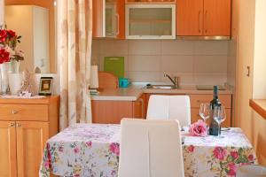 a kitchen with a table and two chairs with wine glasses at Studio Apartment Volta in Crveni Vrh +17 photos