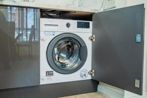 - Lavadora y secadora en una habitación en JB Apartments, Fully Equiped Ground Floor Apartment, en Abbey Wood