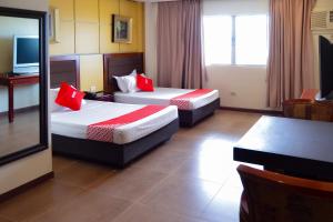 pokój hotelowy z 2 łóżkami i czerwonymi poduszkami w obiekcie Super OYO 791 Bell Mansion w mieście Manila