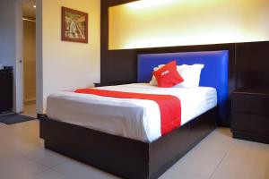 a bedroom with a large bed with a red pillow at Super OYO 791 Bell Mansion in Manila