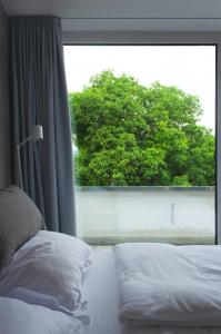 a bedroom with a bed and a large window at seelandsuite Bodensee in Bermatingen