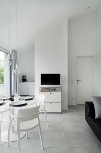 a white living room with a white table and chairs at seelandsuite Bodensee in Bermatingen